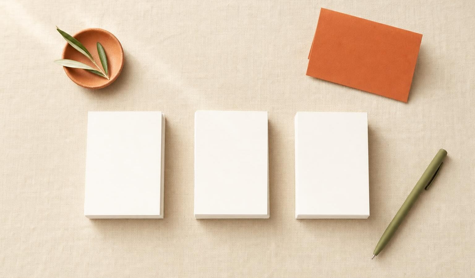 Three separate neat stacks of blank white cards on a linen surface, representing distinct content silos